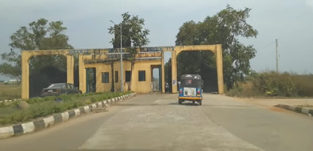 Entrance gate of a university with a tricycle passing through